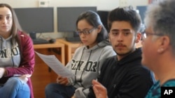 FILE - High school seniors listen to their college-preparation teacher, right, as she leads a discussion about how to adjust to the academic, financial and social pressures of collegiate life, in Santa Fe, New Mexico, Jan. 18, 2018.