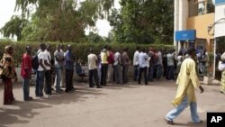 Des gens font la queue devant une banque à Bamako.