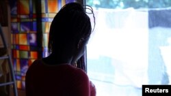 FILE - Nigerian ex-prostitute "Beauty" (a pseudonym), poses in a social support centre for trafficked girls near Catania in Italy, Sept. 14, 2016. 