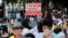 FILE - A man wearing a protective mask holds a placard reading "Taiwan in solidarity with Hong Kong," as people demonstrate in support of Hong Kong protesters opposed to China's national security law, in Paris, France, July 11, 2020.