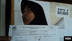 Seorang calon pemilih menunjukkan surat pemberitahuan pemungutan suara untuk memilih ulang di sebuah TPS di Sukoharjo, Jawa Tengah, Kamis, 17 Juli 2014 (Foto: VOA/Yudha)