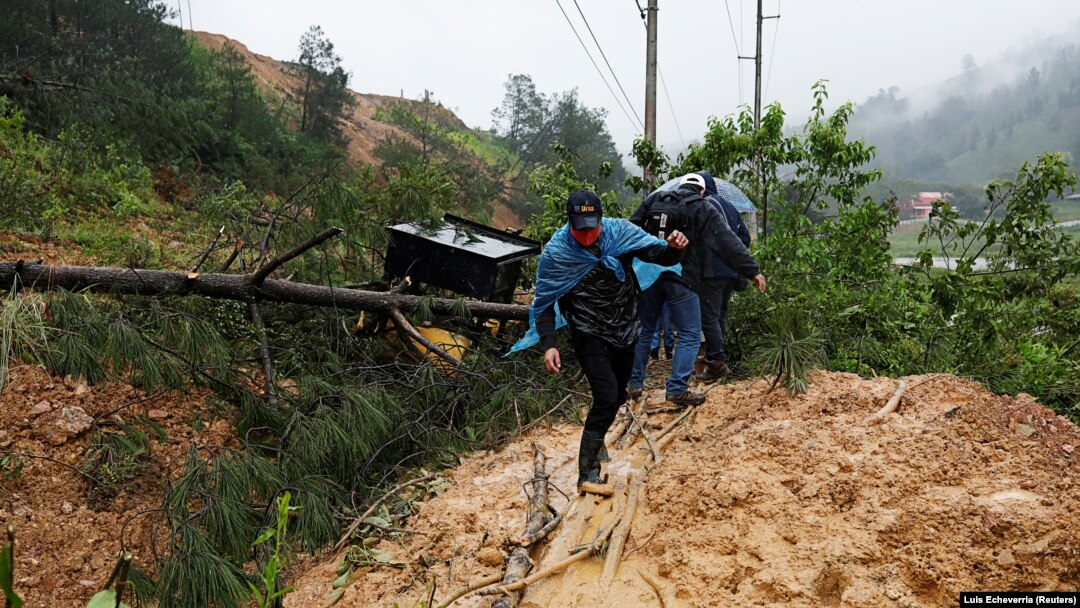 Orang-orang melintasi tanah longsor yang menutupi jalan setelah Badai Eta, di Purulha, Baja Verapaz, Guatemala, 6 November 2020. (Foto: REUTERS/Luis Echeverria)