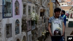 A man carries a decorated human skull after praying at the General Cemetery during the Natitas Festival in La Paz, Bolivia, Nov. 8, 2018.