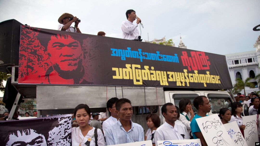 FILE - Activists hold placards during a protest against the killing of Aung Kyaw Naing, a freelance journalist, outside the city hall in Yangon, Myanmar, Oct. 26, 2014. 