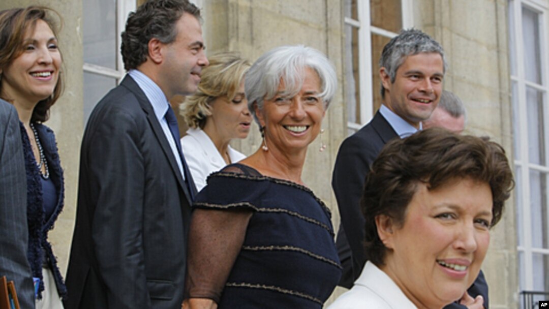 French Finance Minister Christine Lagarde, center, stands with ministers as she leaves the Elysee Palace in Paris, after the weekly Cabinet meeting, June 29, 2011