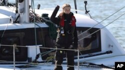 Climate activist Greta Thunberg waves as she arrives in Lisbon aboard the sailboat La Vagabonde, Dec 3, 2019. 