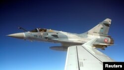 A French Mirage fighter plane demonstrates the interception of a Belgian air force transport plane as they fly over France, Sept. 12, 2018 as part of NATO drills. 