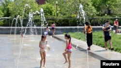 Sekelompok anak-anak bermain di air mancur di Taman North End di Boston, Massachusetts, di tengah gelombang panas yang melanda AS pada 22 Mei 2022. (Foto: Reuters/Katherine Taylor)