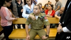 FILE - Israeli solider Elor Azaria sits inside an Israeli military court in Tel Aviv, Israel, in an April 18, 2016, photo. If convicted, Azaria faces up to 20 years in prison.