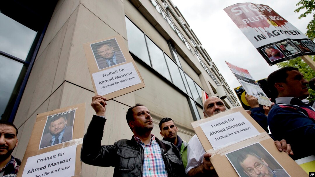 Orang-orang protes di depan sebuah pengadilan menuntut pembebasan wartawan Al-Jazeera, Ahmed Mansour di Berlin, Jerman, Minggu, 21 Juni 2015.