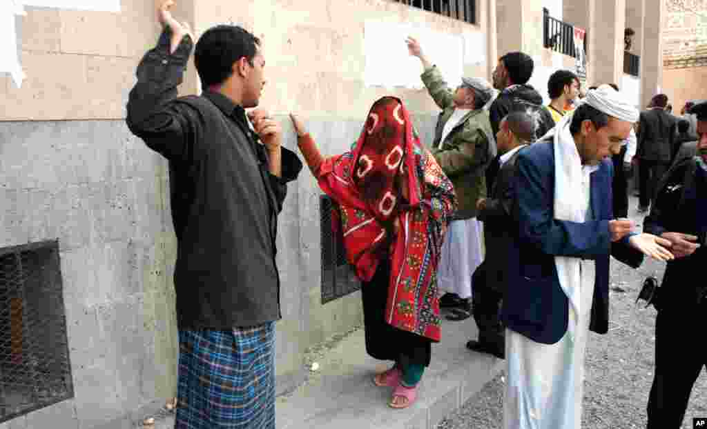 Voters scan the lists at a polling station in Sana'a, Yemen, February 21, 2012. (VOA - E. Arrott)