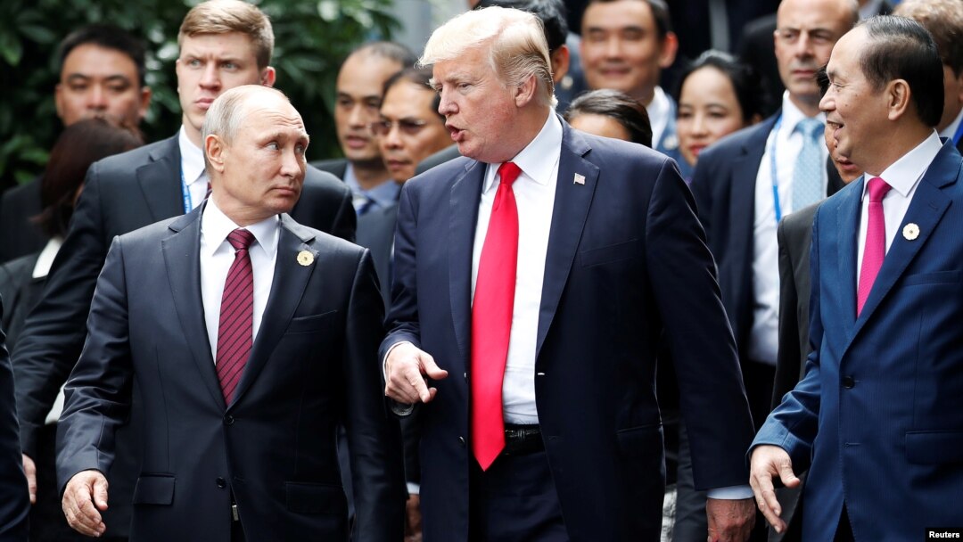 Predsednik SAD Donald Tramp i predsednik Rusije Vladimir Putin razgovaraju, dok predsednik Vijetnama Tran Dai Kvang, desno, gleda u njih, tokom foto sesije na samitu APEC-a u Danangu, Vijetnam, 11. novembra 2017.