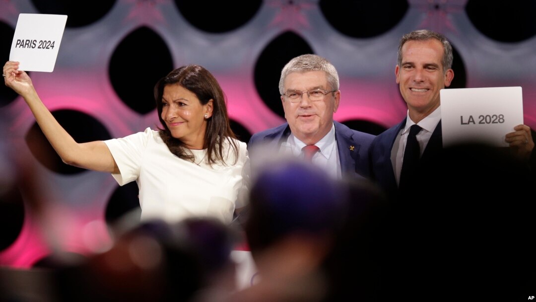 Ketua Komite Olimpiade Internasional (IOC) Thomas Bach (tengah) berpose bersama Walikota Paris Anne Hidalgo (kiri) dan Walikota Los Angeles Eric Garrett di markasa IOC di Lima, Peru, Rabu (13/9). 