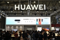 FILE - People gather at a Huawei stand during the Consumer Electronics Show, Ces Asia 2019 in Shanghai, June 11, 2019.