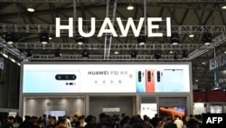 FILE - People gather at a Huawei stand during the Consumer Electronics Show, Ces Asia 2019 in Shanghai, June 11, 2019. 