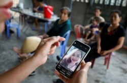 A relative looks at an image of Anna Bui Thi Nhung, who was found dead in the back of a British truck last month, at her home in Nghe An province, Vietnam Oct. 26, 2019.