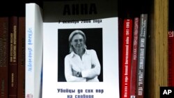 A portrait of investigative reporter Anna Politkovskaya with the words 'the killers are still at large' is displayed on a bookshelf in the offices of the Novaya Gazeta newspaper in Moscow, Russia, Oct. 7, 2021.