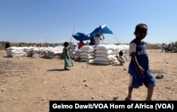 A boy walks by food rations in Afar, Ethiopia.