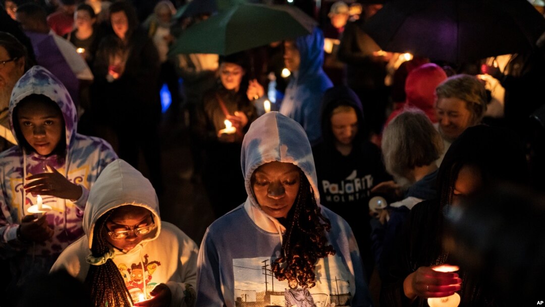 People hold candles during a vigil for the centennial commemorations of the Tulsa Race Massacre in the historic Greenwood neighborhood, May 31, 2021, in Tulsa, Okla.