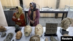 Trabajadoras del Museo Nacional Afgano en Kabul observan piezas que fueron devueltas desde Estados Unidos, en una imagen del 29 de abril de 2021.