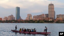 Un bote se desplaza a lo largo de Cambridge, Massachusetts, el lunes, 27 de julio de 2015, frente a Boston, después que el COI cortara vínculos con la ciudad.