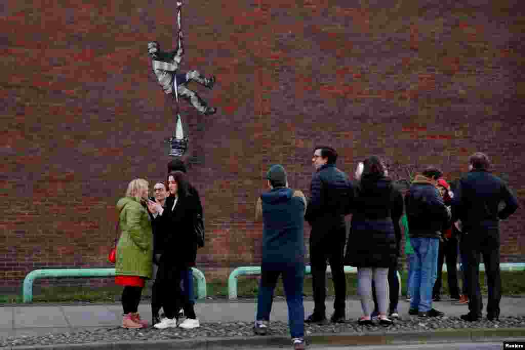 People look at of a mural by artist Banksy on a wall at HM Reading Prison in Reading, Britain, March 1, 2021.