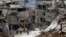 Residents walk through rubble with damaged electricity lines at the mountain resort town of Zabadani in the Damascus countryside, Syria, May 18, 2017.