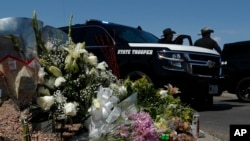 Flowers adorn a makeshift memorial near the scene of a mass shooting at a shopping complex in El Paso, Texas, Aug. 4, 2019.