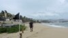 Un hombre camina por una playa con bandera negra, lo que indica que las condiciones son extremadamente peligrosas, con motivo del huracán Kay, en Cabo San Lucas, en Baja California, México, el 6 de septiembre de 2022.