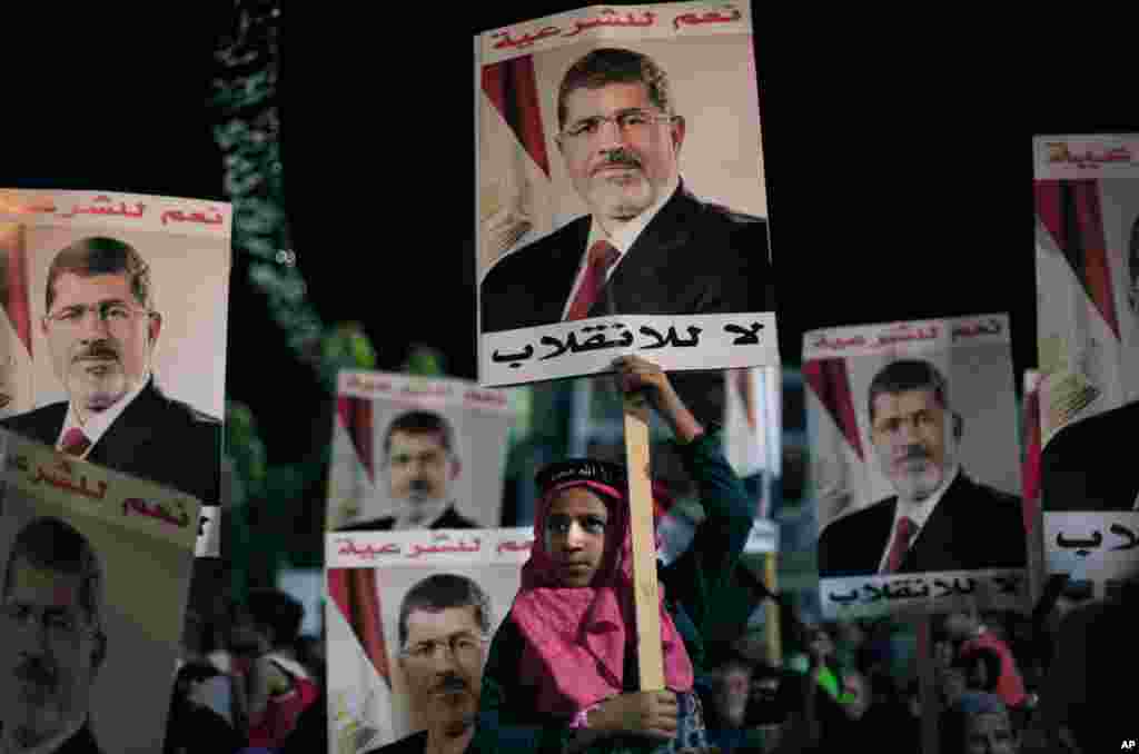 Supporters of Egypt&#39;s ousted President Mohamed Morsi carry posters with Arabic writing which reads &quot;Yes for legality, No for the coup&quot; during a protest outside Rabaah al-Adawiya mosque, Cairo, August 6, 2013.