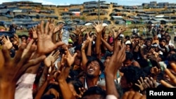 FILE - Rohingya refugees stretch their hands to receive aid given out by local organizations at Balukhali makeshift refugee camp in Cox's Bazar, Bangladesh, September 14, 2017. (REUTERS/Danish Siddiqui/File Photo)