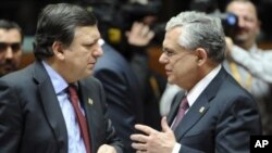 European Commission President Jose Manuel Barroso, left, speaks with Greek Prime Minister Lucas Papademos during a round table meeting at an EU summit in Brussels, January 30, 2012.