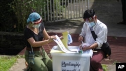 Petugas dari Komisi Pemilihan Umum mengatur surat suara untuk pemungutan suara awal untuk pemilihan umum 8 November mendatang di pinggiran Yangon, Myanmar, 29 Oktober 2020. (Foto: AP)