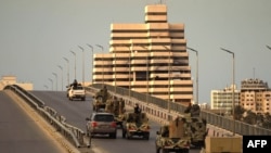 Fighters of a military battalion loyal to Libyan General Khalifa Hafta patrol the streets in the eastern city of Benghazi during a state of emergency to combat the coronavirus disease outbreak, March 21, 2020. 