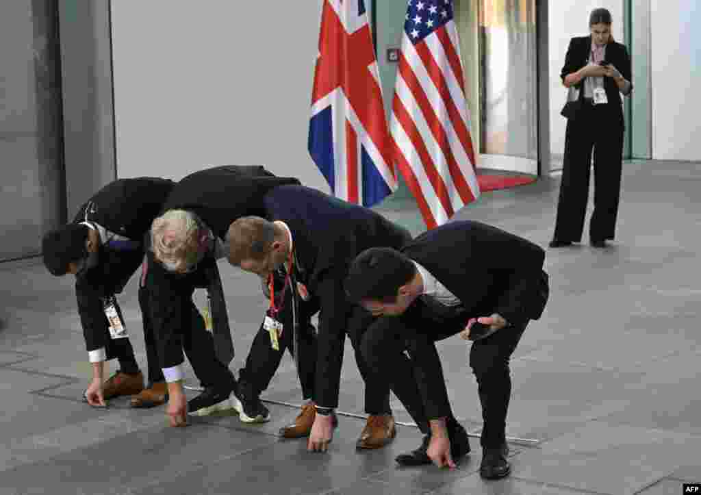 Staff members put names on the floor for the family photo of the &quot;Quad meeting&quot; held by the German Chancellor, the U.S. President, the French President and the British Prime Minister at the Chancellery in Berlin.