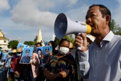FILE - Rong Chhun, president of Cambodia's Independent Teachers' Association, speaks at a factory workers' protest calling for benefits after their textile factory was shuttered amidst the coronavirus pandemic in Phnom Penh, July 29, 2020.