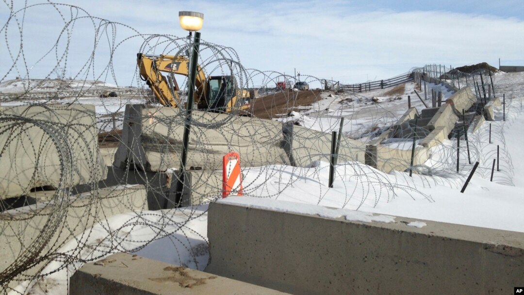 FILE - Razor wire and concrete barriers protect access to the Dakota Access pipeline drilling site, Feb. 9, 2017, near Cannon Ball, North Dakota.