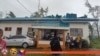 In this photo provided by Philippine Coast Guard, its members stand outside their building damaged by Typhoon Yinxing in Santa Ana, Cagayan province, northern Philippines, Nov. 7, 2024.