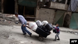 Người dân kéo hành lý rời khỏi khu vực Sheikh Maqsud ở Aleppo, Syria, 4/42013 