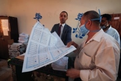 Seorang pejabat pemilu memberikan keterangan kepada seorang pemilih di sekolah yang digunakan sebagai TPS dalam pemilihan senat Mesir di Kairo, Mesir, 11 Agustus 2020. REUTERS / Amr Abdallah Dalsh