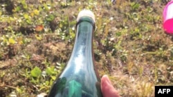 A message is seen in a bottle that was found on the shoreline in Shishmaref, Alaska, August 5, 2019. Tyler Ivanoff, a teacher's aide, was gathering firewood when he discovered the bottle. 