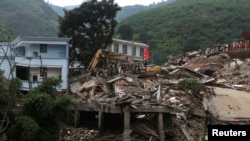 Sebuah ekskavator memindahkan puing-puing untuk mencari mayat korban gempa di Zhaotong, Luding, Provinsi Yunnan, China. (Foto: Reuters)