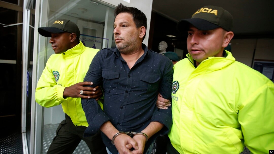 Polisi Kolombia membawa tersangka Raul Gutierrez dalam sidang di pengadilan Bogota, Kolombia, Kamis (15/4). 