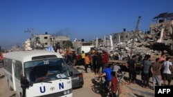 Autobus UN-a prolazi pored uništene zgrade nakon izraelskog bombardiranja Rafaha u južnom pojasu Gaze 10. novembra 2023.
