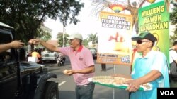 Aksi bagi-bagi telur rebus jelang Ramadan di Solo. (VOA/Yudha Satriawan)