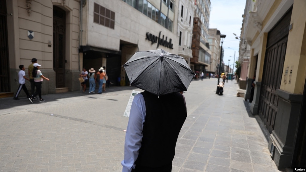 Un hombre camina por las calles del centro de la ciudad con un paraguas debido a las altas temperaturas en Lima, Perú, el 25 de febrero de 2024.