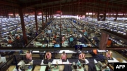 Algunos de los 15.000 trabajadores textiles de la Zona Franca de Tipitapa, en las afueras de Managua, confeccionan ropa, el 14 de mayo de 2001.