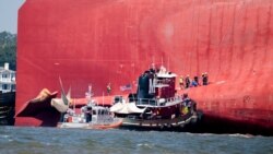 Rescuers work near the stern of the vessel Golden Ray as it lays on its side near the Moran tug boat Dorothy Moran, Sept. 9, 2019, in Jekyll Island, Georgia. The Golden Ray cargo ship is capsized near a port on the Georgia coast.