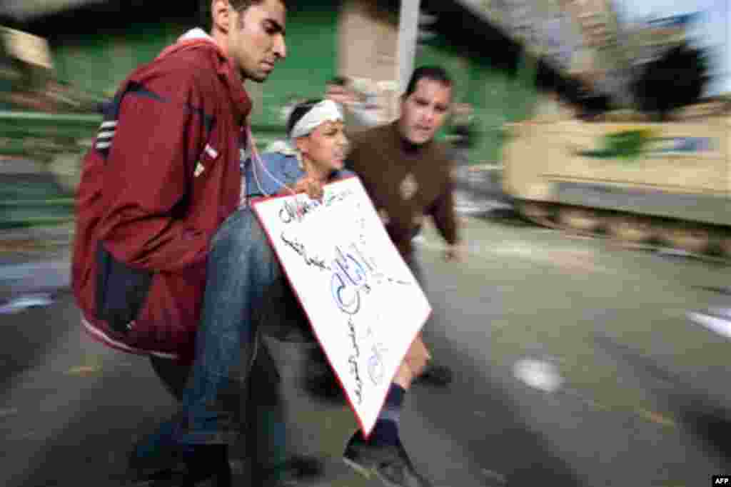 An injured anti-Mubarak protester is carried in Cairo, Egypt, Wednesday, Feb. 2, 2011. Several thousand supporters of President Hosni Mubarak, including some riding horses and camels and wielding whips, clashed with anti-government protesters Wednesday a