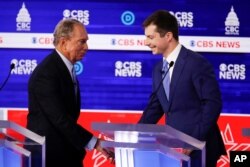 From left, Democratic presidential candidates, former New York City Mayor Mike Bloomberg, and former South Bend Mayor Pete Buttigieg, shake hands on stage at the end of the Democratic presidential primary debate Feb. 25, 2020, in Charleston, S.C.